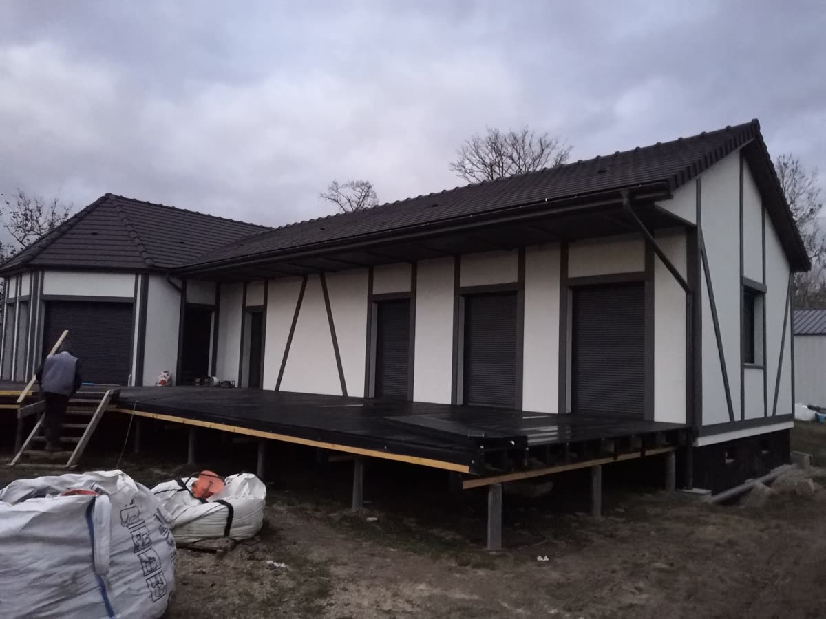 Maison en bois implantée sur un terrain arboré