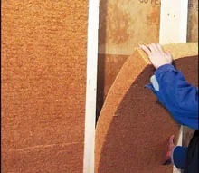 Pose d’un isolant en fibre de bois dans une paroi
